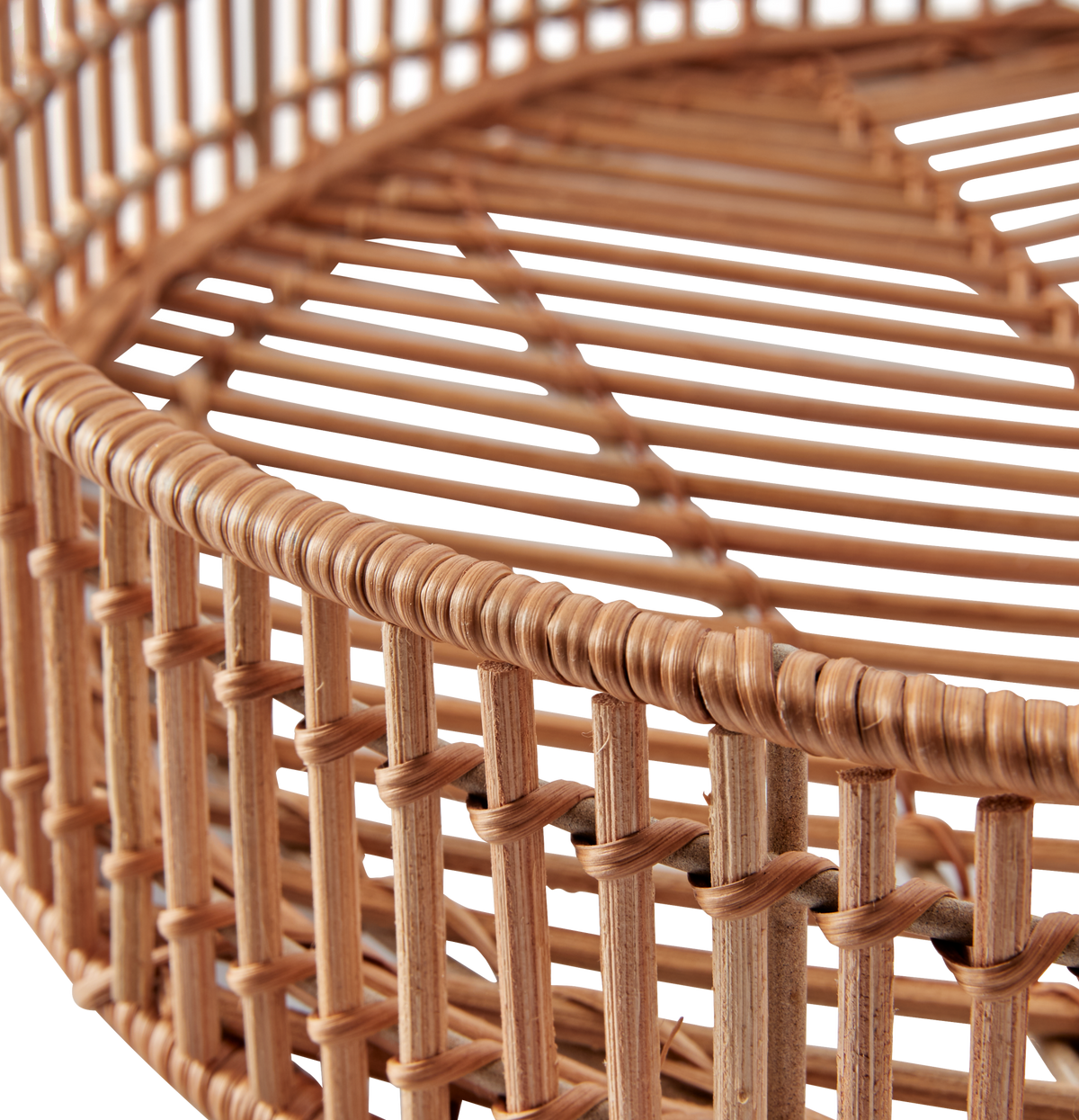 Nærbillede af rund flettet rattan-kurv med lodret og vandret mønster.