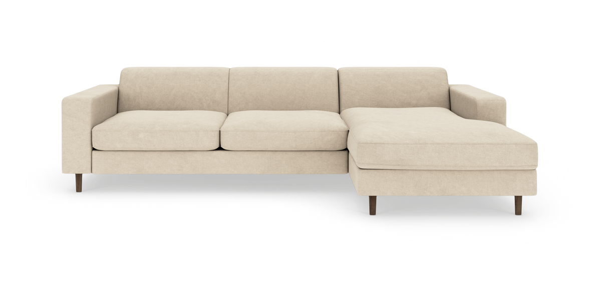 Beige hjørnesofa med højrevendt chaiselong og træben, lige armlæn, frilagt på hvid baggrund.