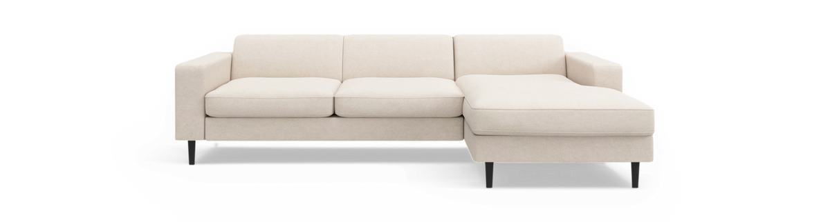 Beige hjørnesofa med højre chaiselong, tre sæder og slanke sorte ben, frilagt.