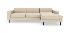 Beige hjørnesofa med chaiselong på højre side, sorte koniske ben og lige armlæn på hvid baggrund.