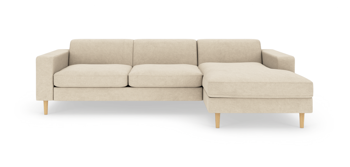 Beige modulsofa med chaiselong til højre og lyse træben på hvid baggrund.