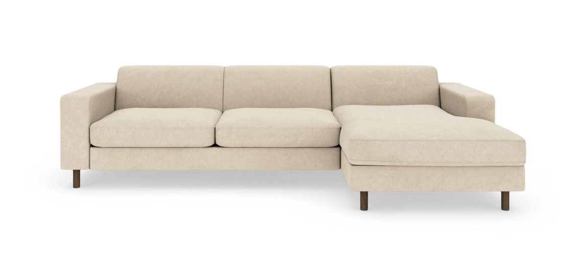 Beige hjørnesofa med chaiselong til højre på træben, frilagt mod hvid baggrund.