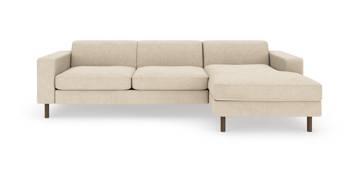 Beige modulsofa med chaiselong til højre og runde træben, frilagt på hvid baggrund.