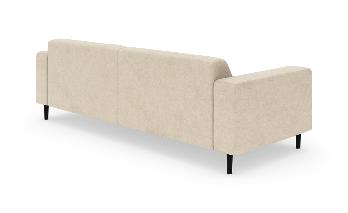 Beige sofa med rene linjer set bagfra i studiemiljø, med slanke sorte ben.