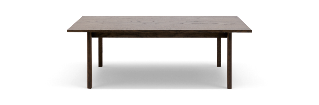 Rektangulært spisebord i mørkbejdset eg med slanke runde ben, fritlagt mod hvid baggrund.