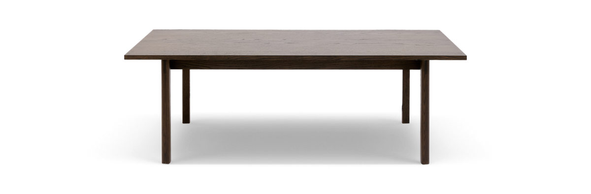 Rektangulært spisebord i mørkbejdset eg med slanke runde ben, fritlagt mod hvid baggrund.