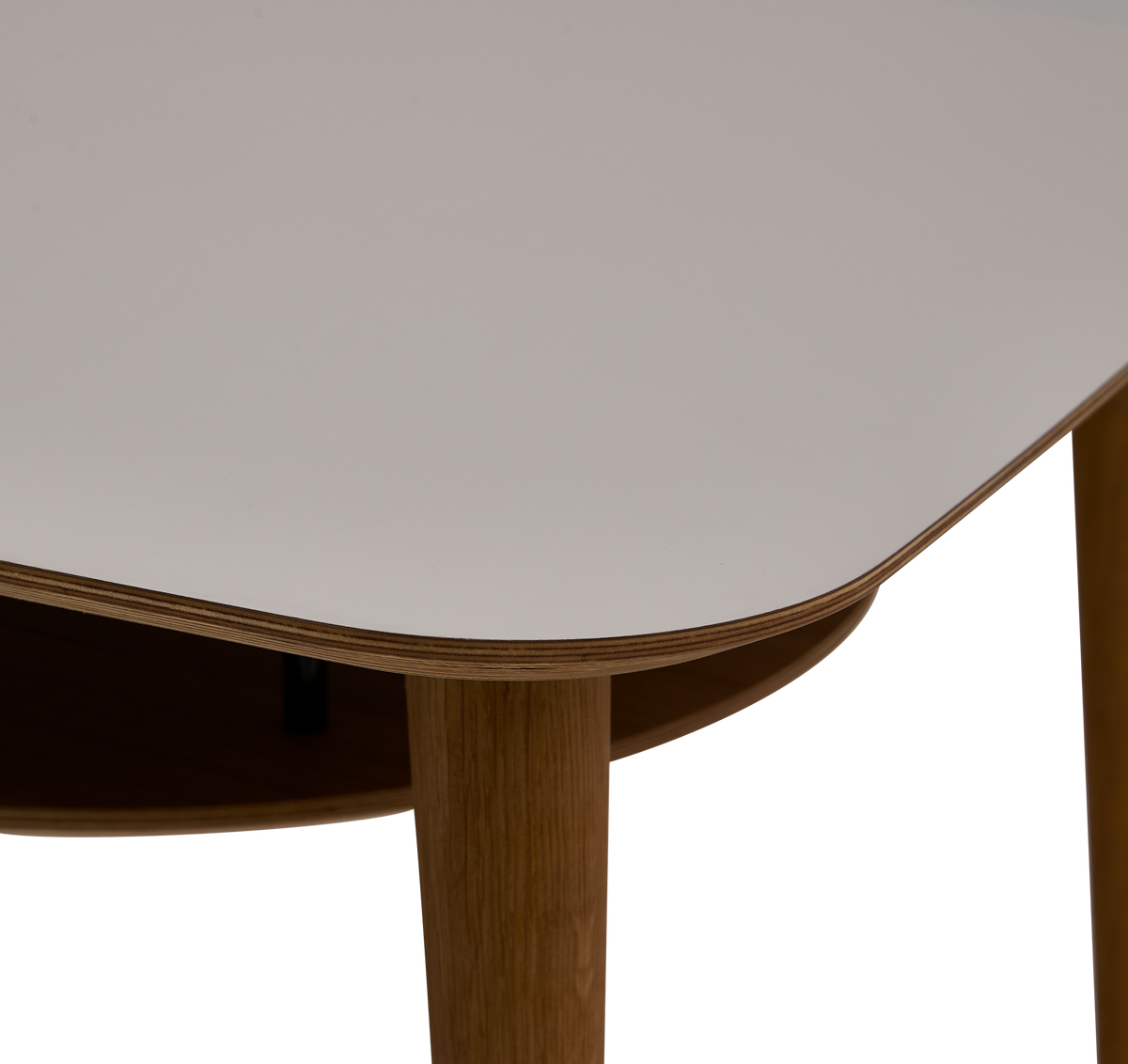 Detalje af hvid bordplade med afrundet hjørne og egetræsben, med hylde under.