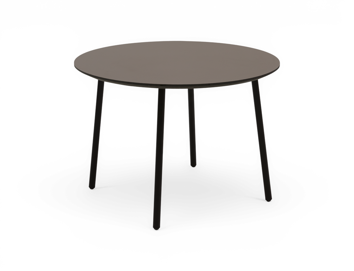 Rundt spisebord med grå bordplade og slanke sorte ben.