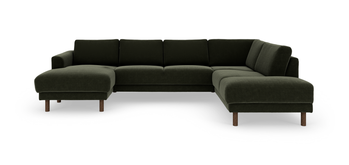 Mørkegrøn U‑sofa i stof med chaiselong til venstre og åben afslutning til højre, på runde træben.