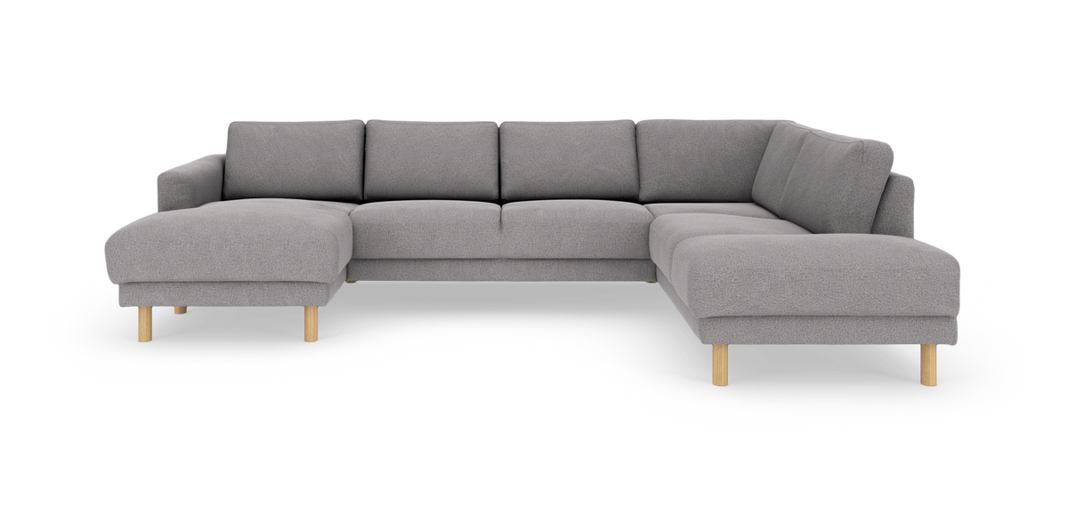 Grå modulær hjørnesofa med chaiselong i begge ender og lyse træben, frilagt på hvid baggrund.