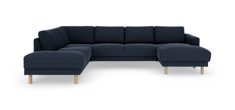 Mørkeblå modulær hjørnesofa med chaiselong til højre og lyse træben, frilagt på hvid baggrund.