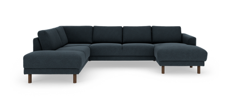 Mørkeblå hjørnesofa i modulopbygning med dobbelt chaiselong og runde træben, frilagt på hvid baggrund.