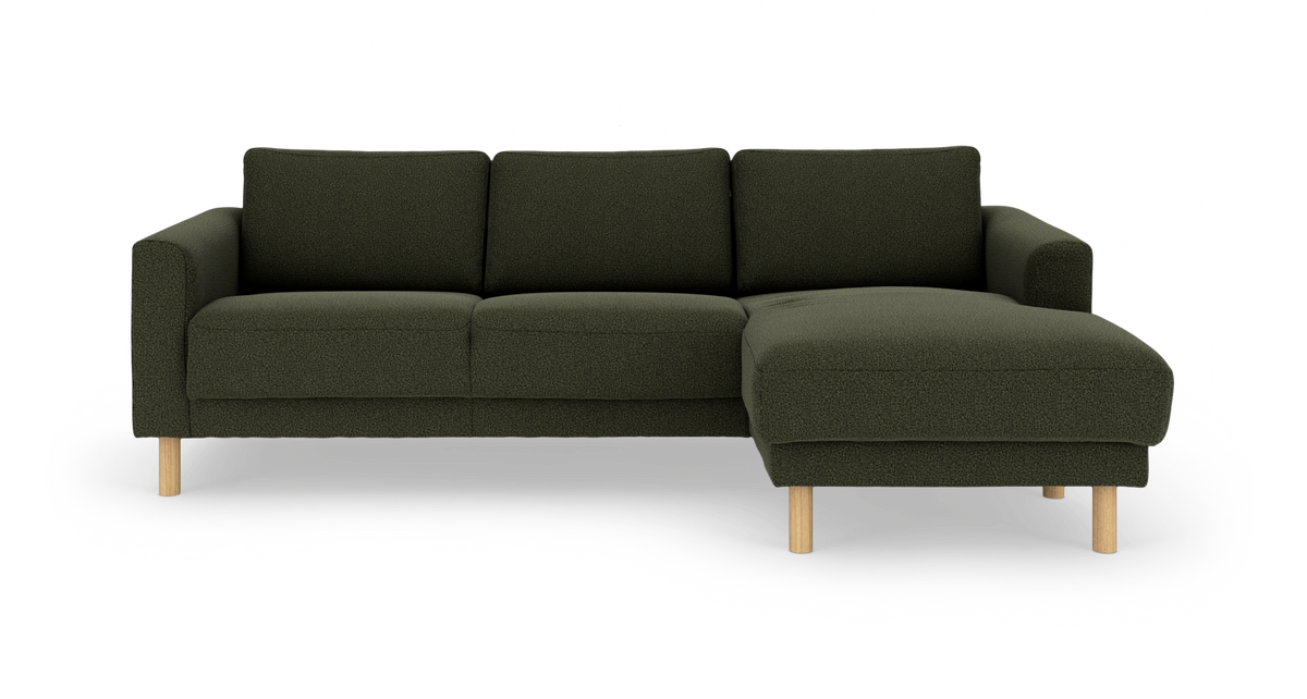 Mørkegrøn hjørnesofa med chaiselong til højre og runde træben, frilagt på hvid baggrund.