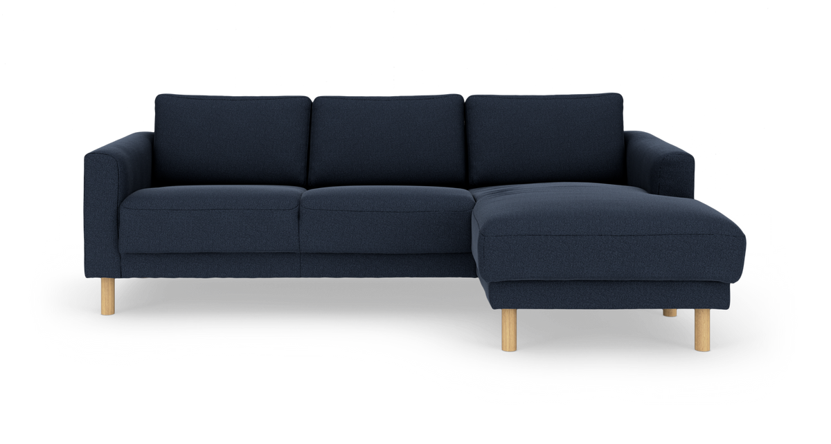 Mørkeblå hjørnesofa med højre chaiselong og lyse træben, fritlagt på hvid baggrund.