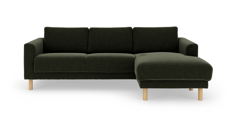 Mørkegrøn tresæders sofa med chaiselong til højre og runde lyse træben, frilagt på hvid baggrund._ps