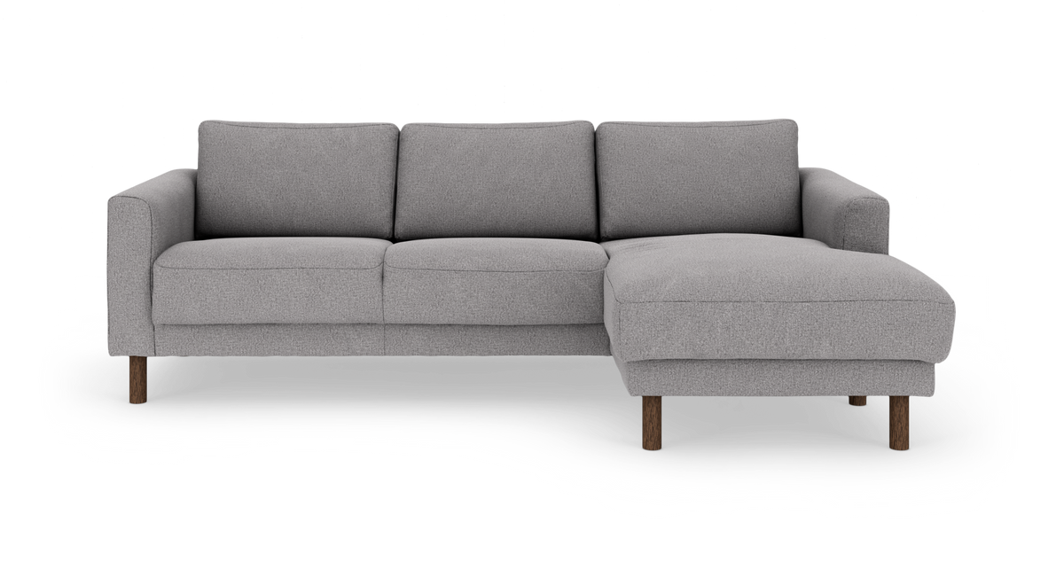 Grå 3‑personers sofa med højrevendt chaiselong og træben, frontvisning.