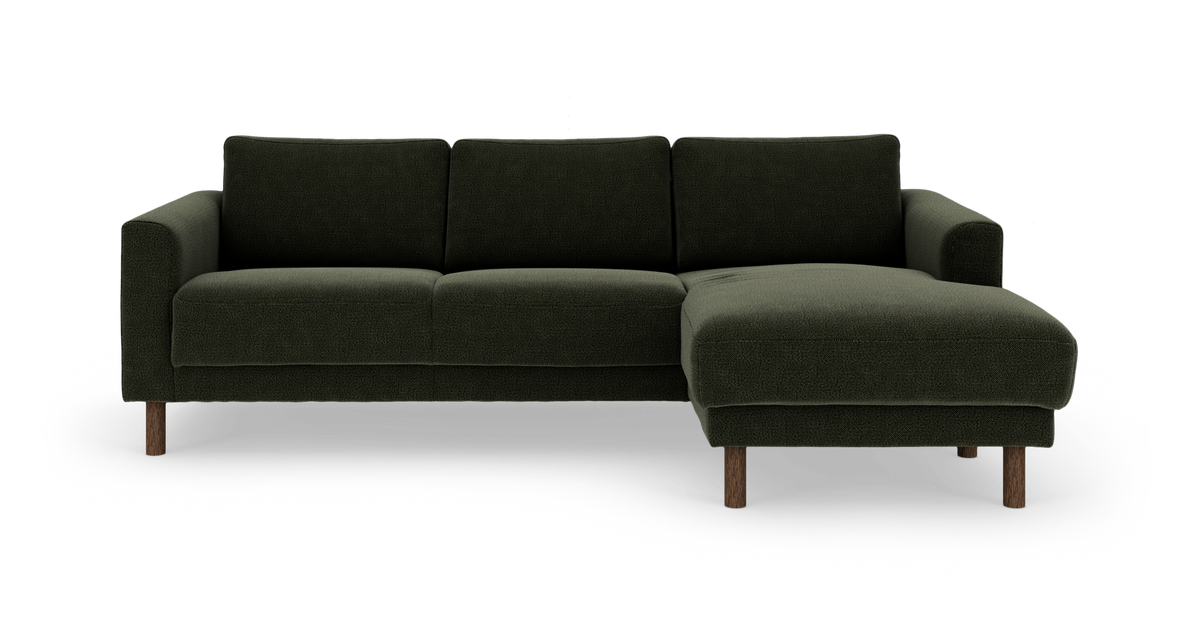 Mørkegrøn modulsofa med chaiselong til højre, træben, fotograferet forfra mod hvid baggrund.