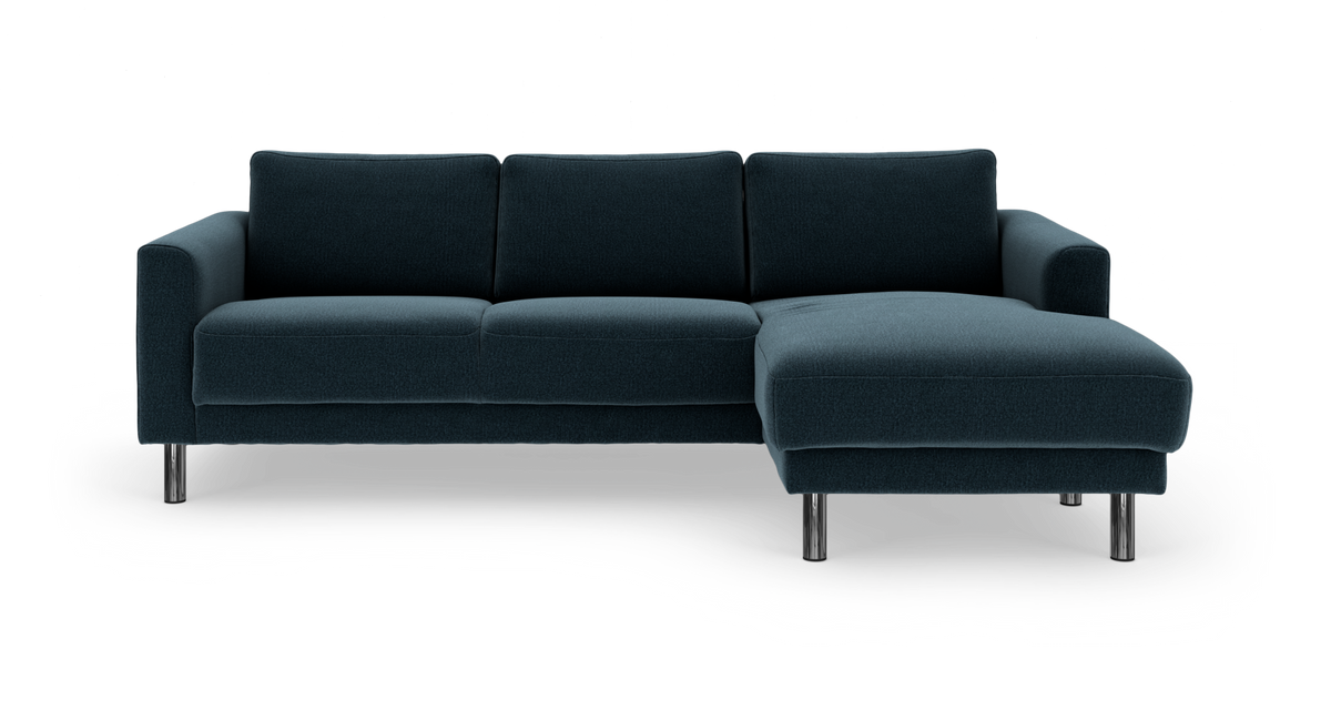 Mørk blågrøn hjørnesofa med chaiselong til højre og kromben, fritlagt på hvid baggrund.