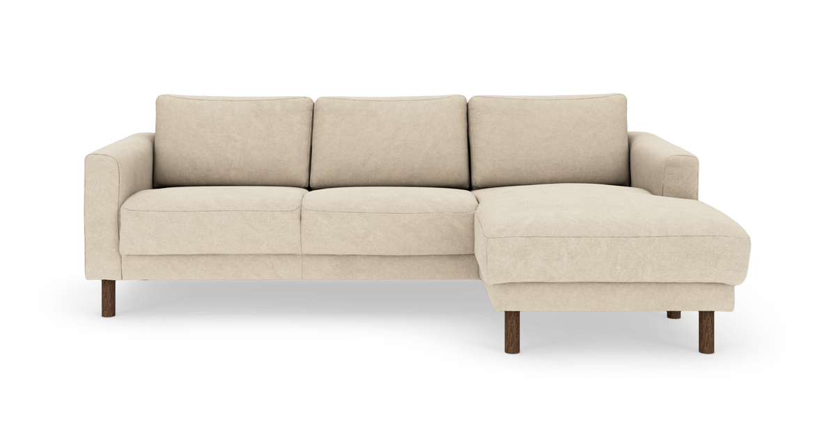 Beige hjørnesofa med højrevendt chaiselong på træben, frilagt.