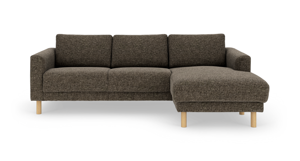 Mørkebrun hjørnesofa med chaiselong til højre og lyse træben.