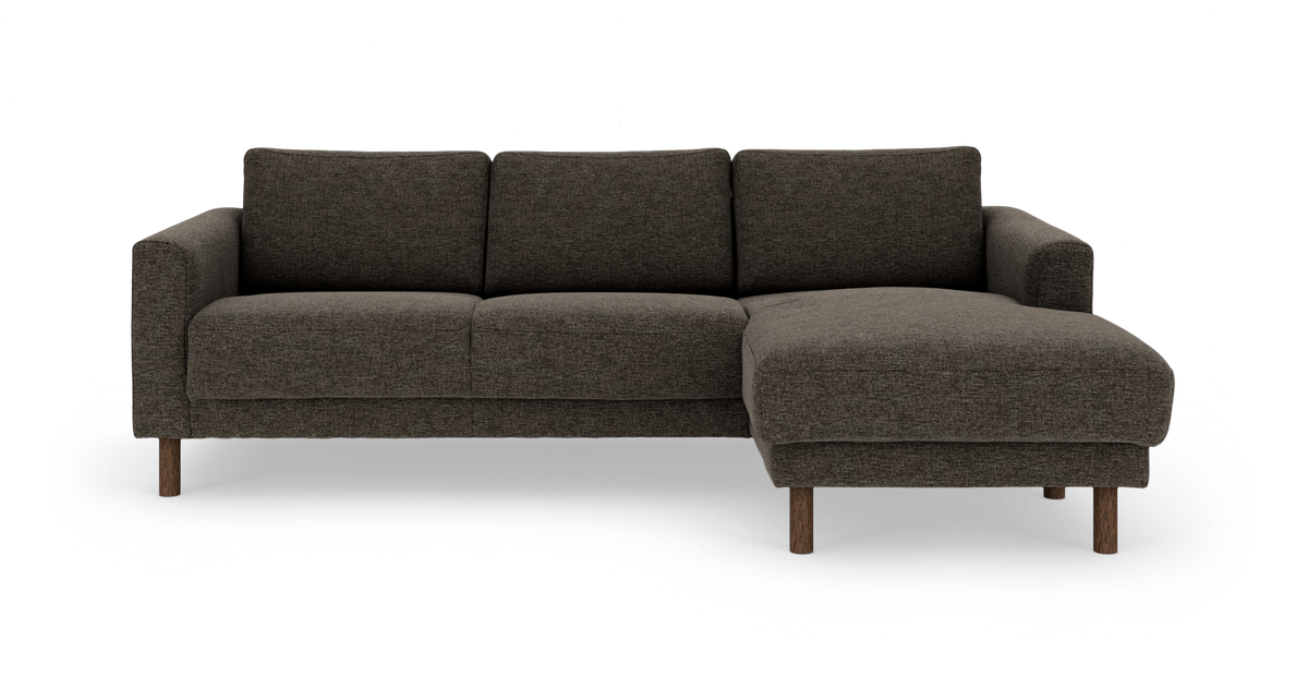 Mørkegrå hjørnesofa med chaiselong til højre og runde træben.