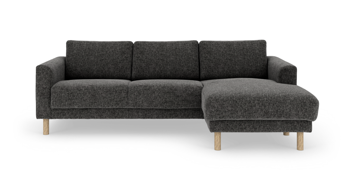 Mørkegrå hjørnesofa med højre chaiselong og lyse træben.