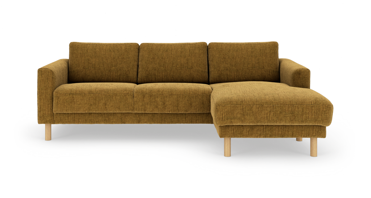 Hjørnesofa med chaiselong til højre i sennepsgul stof med lyse træben – frontvisning, fritlagt produktbillede.