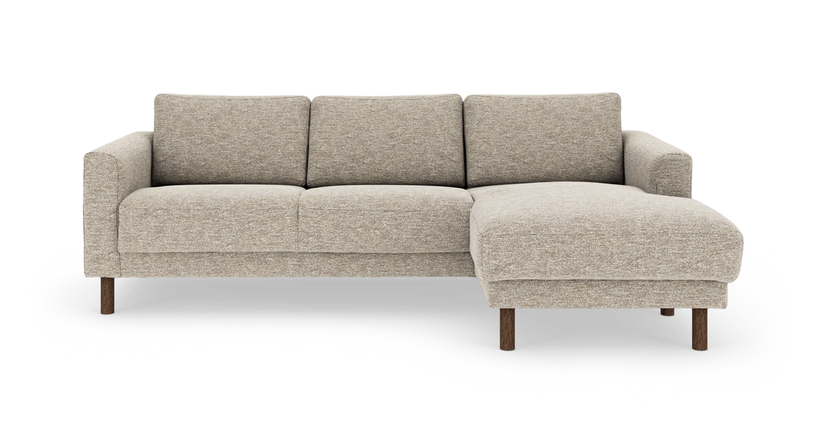 Beige 3-personers sofa med højrevendt chaiselong, stofbetræk og træben, frilagt på hvid baggrund.
