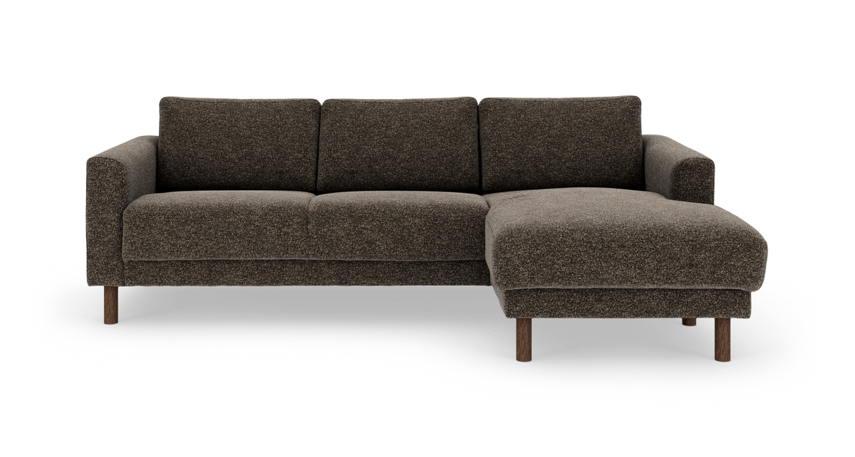 Mørkebrun L‑sofa med højrevendt chaiselong, polstret i stof og med træben, frilagt frontvisning i studiemiljø.
