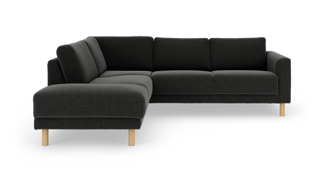 Mørkegrå L‑sofa med chaiselong til venstre og lyse træben, frilagt på hvid baggrund.