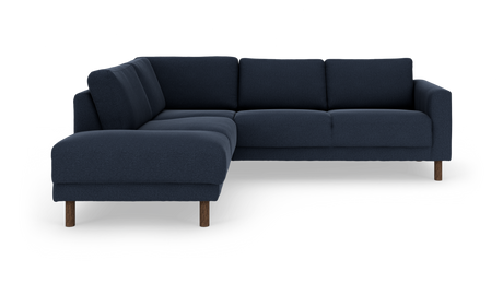 Mørkeblå L‑formet hjørnesofa med venstre chaiselong og træben, fotograferet på hvid studiebaggrund.