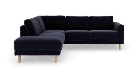 Mørkeblå L‑formet hjørnesofa med træben på hvid studiobaggrund.