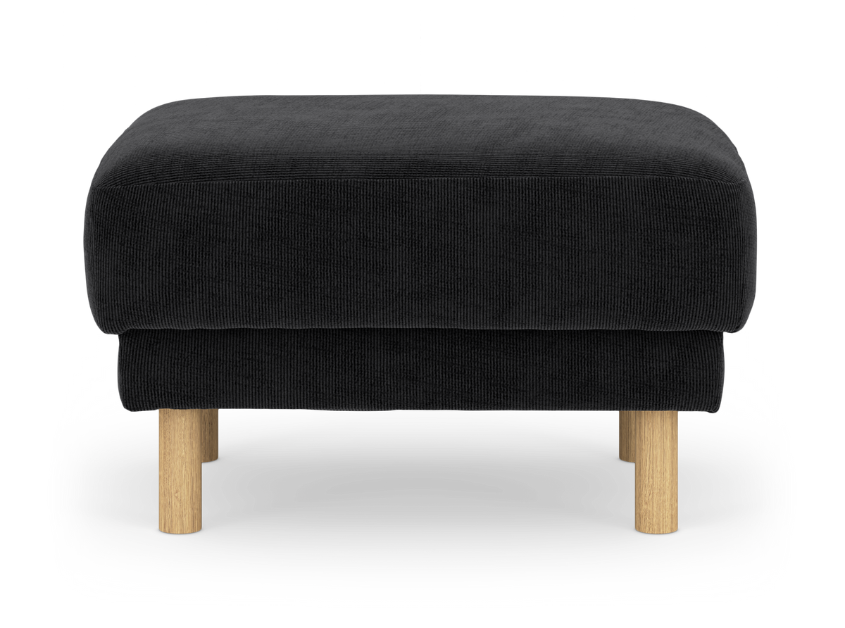 Sort skammel/ottoman med runde træben, set forfra på hvid baggrund.