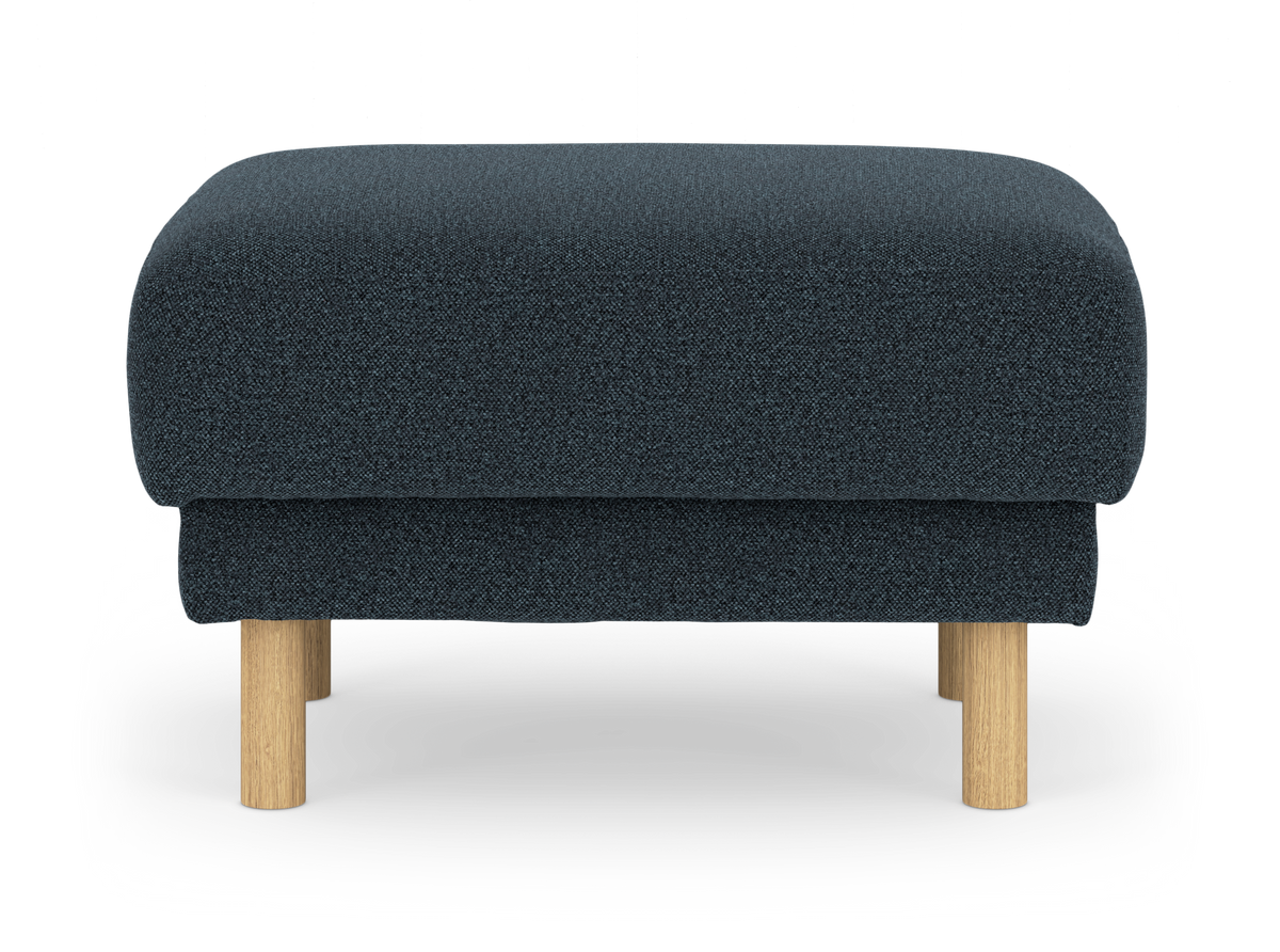 Mørkeblå ottoman/skammel i tekstil med lyse træben, frilagt set forfra.