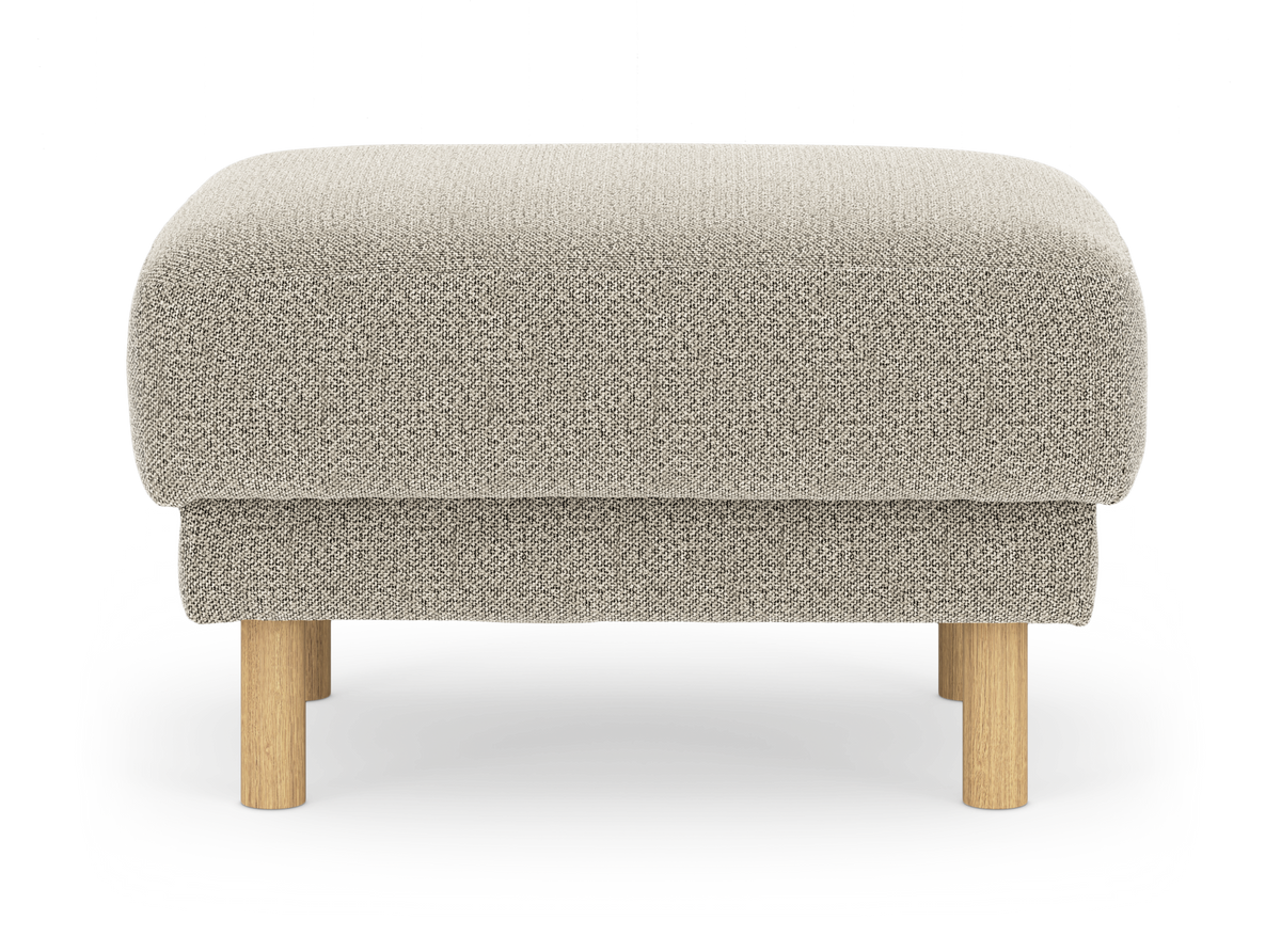 Beige puf i tekstil med runde ben i lyst træ, frilagt på hvid baggrund.