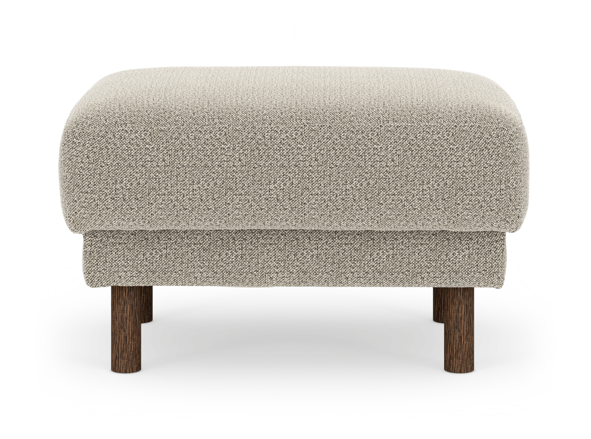 Beige puf i tekstil med runde ben i mørkt træ, frilagt på hvid baggrund.