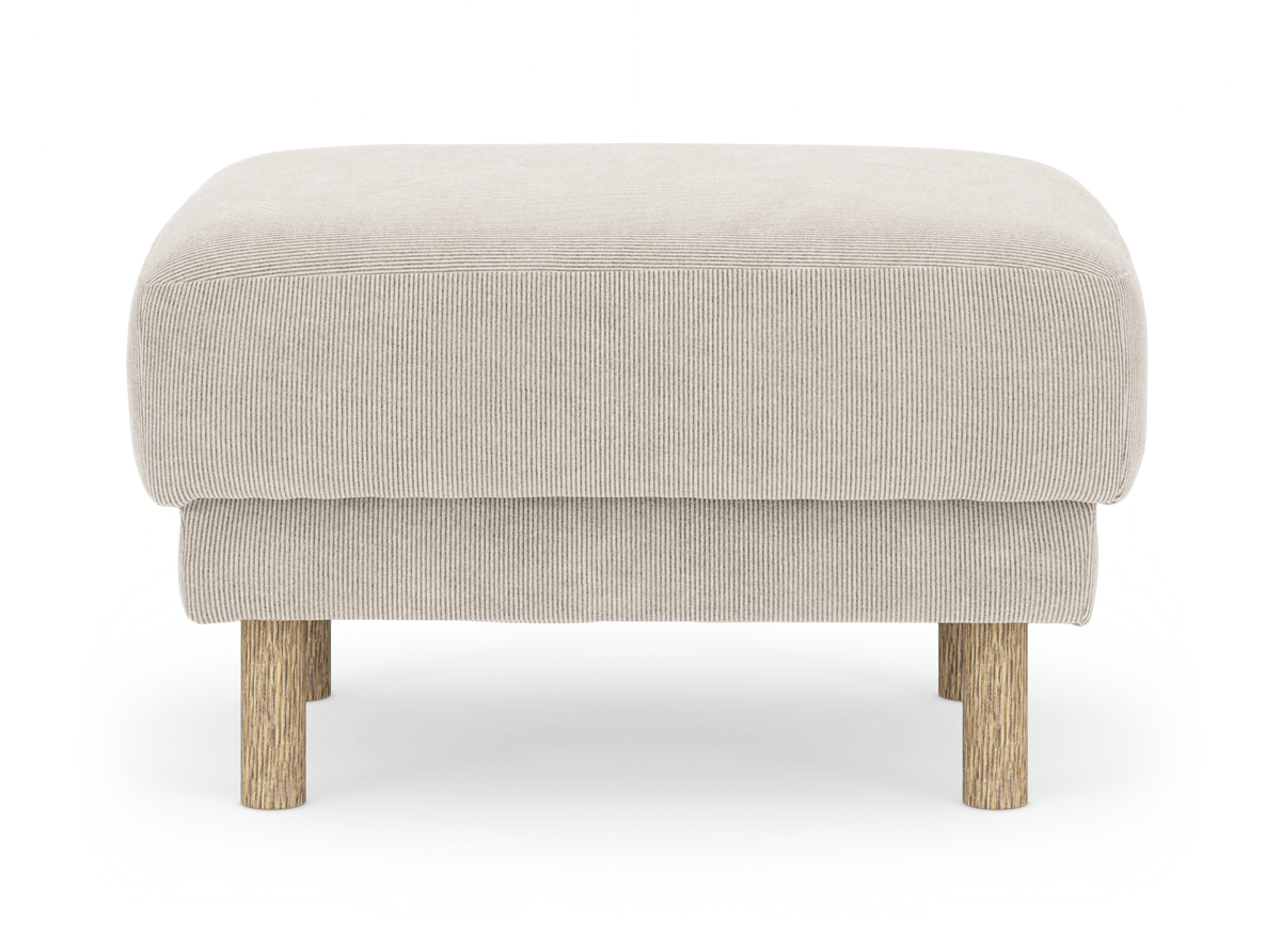 Beige puf i fløjl med runde træben, set forfra.