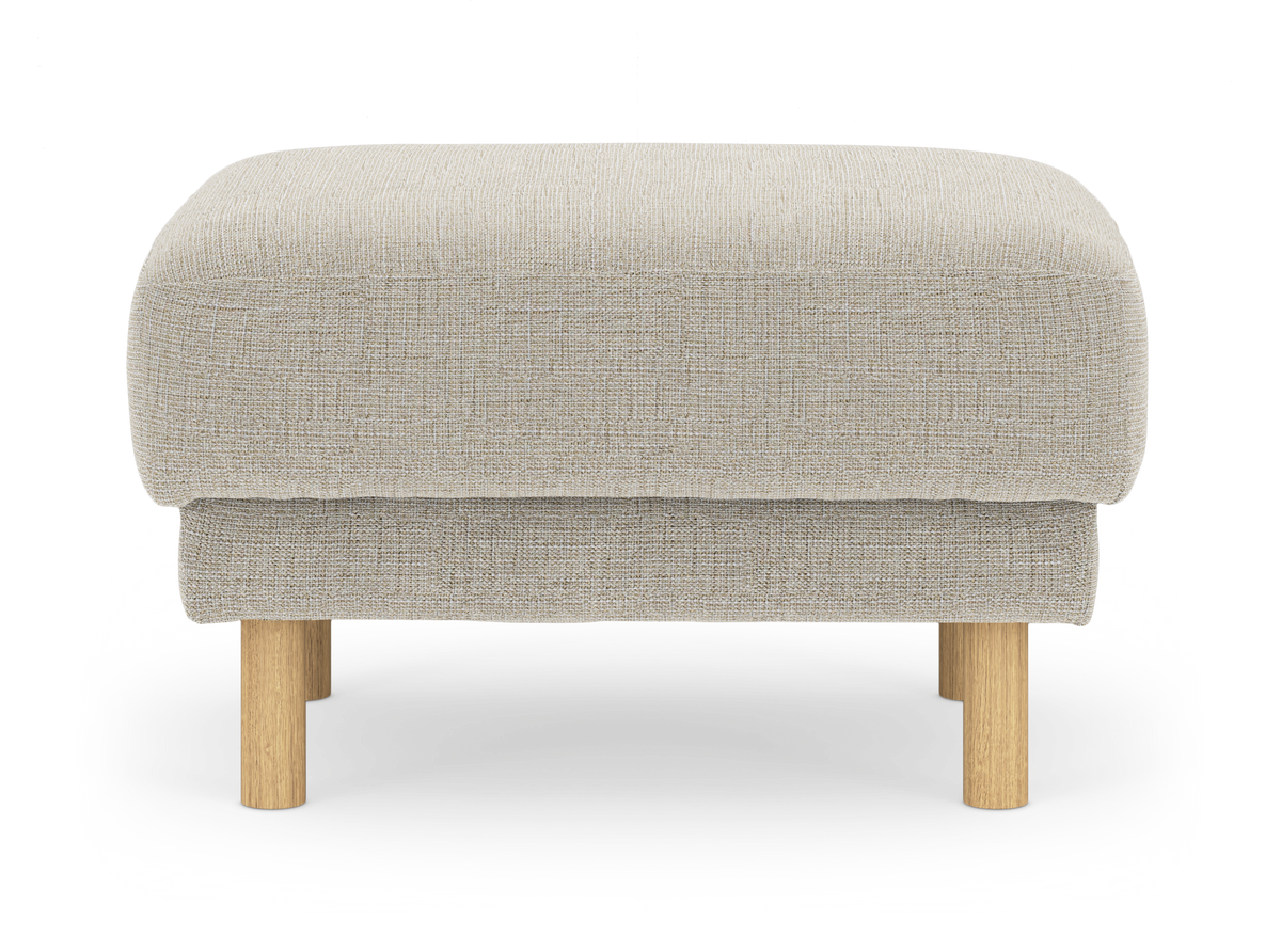 Beige stofpuf med runde ben i lyst træ, frilagt på hvid baggrund.