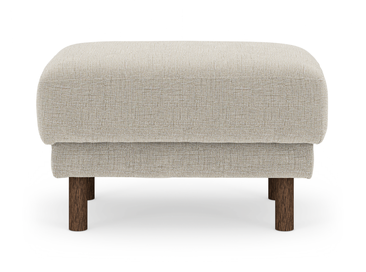 Beige skammel/ottoman i stof med runde mørkebrune træben, frilagt på hvid baggrund.