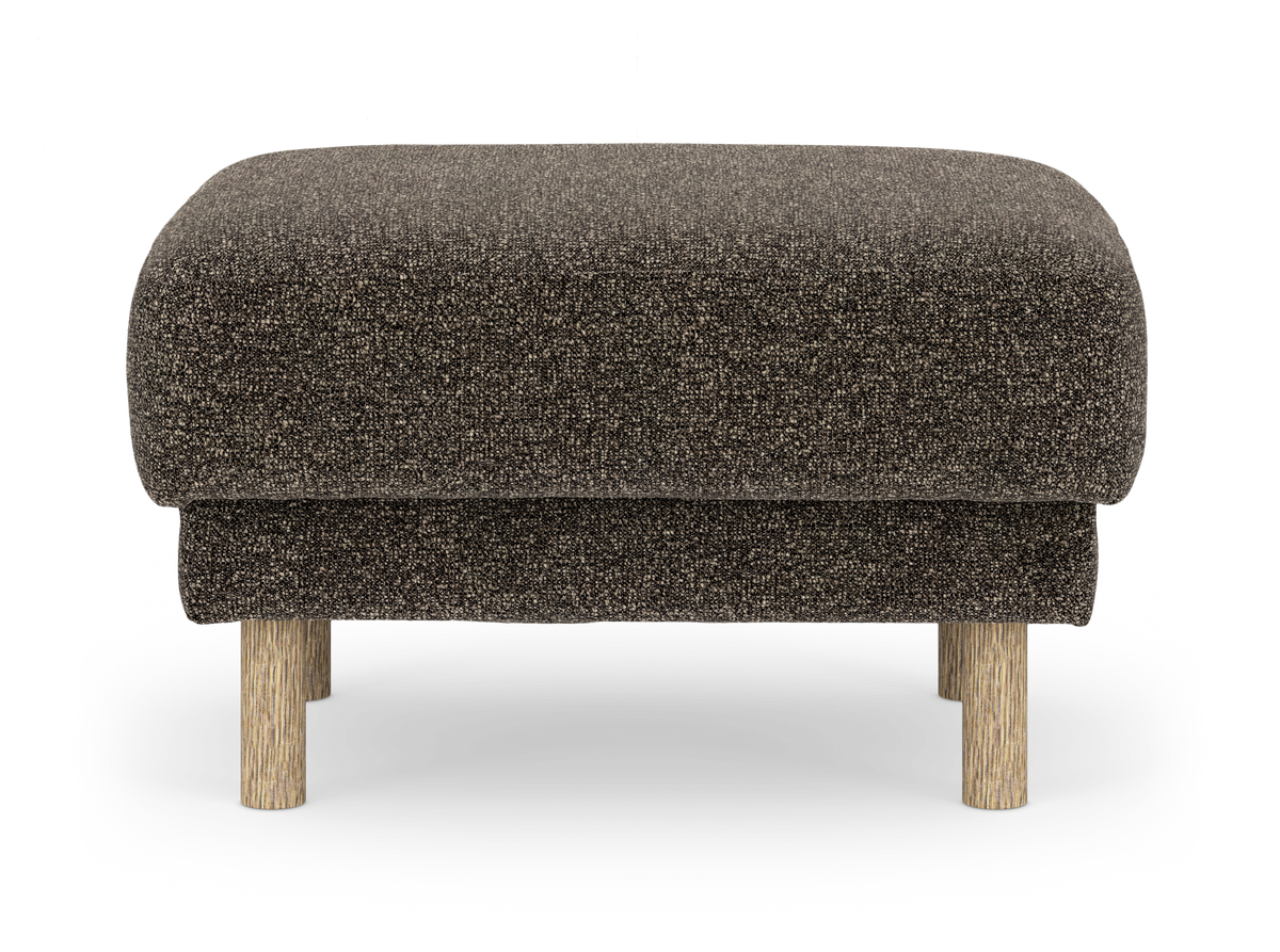 Brun tekstureret skammel/pouf med stofbetræk og lyse runde træben, frilagt på hvid baggrund.