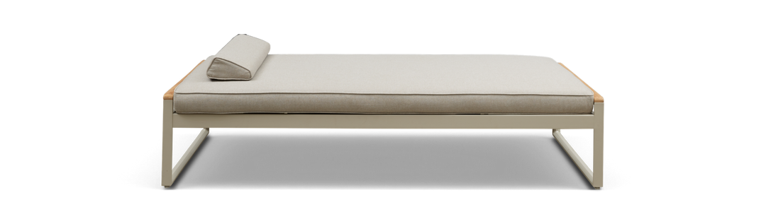Beige daybed med slank metalram og trekantet nakkepude, set direkte forfra i studie.