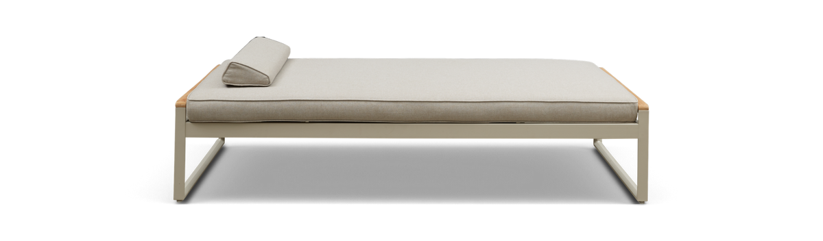 Beige daybed med slank metalram og trekantet nakkepude, set direkte forfra i studie.