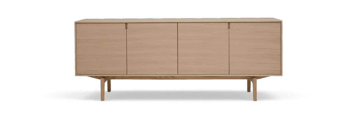 Minimalistisk skænk i lys eg med fire glatte låger på slanke ben, frontview, frilagt.