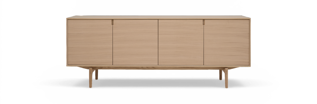 Lyst egetræ sideboard med fire glatte låger og slanke ben, frilagt på hvid baggrund.