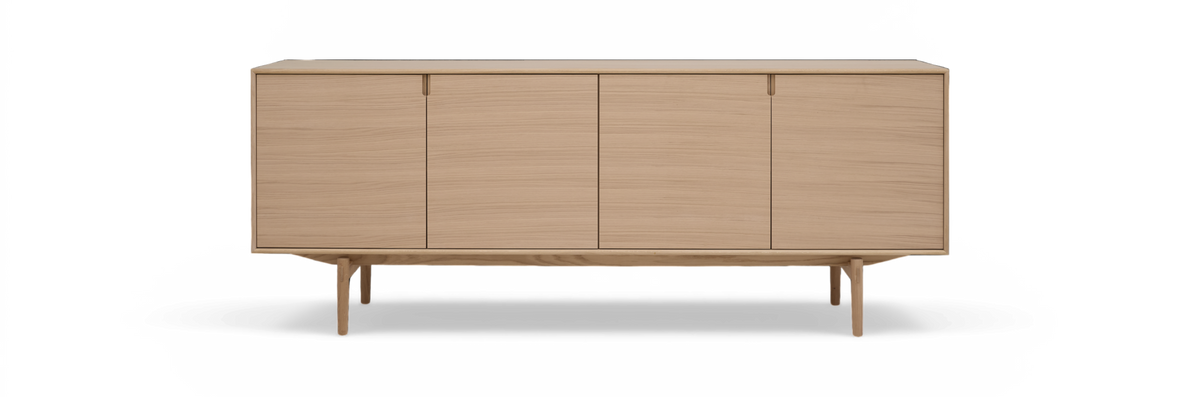 Lyst egetræ sideboard med fire glatte låger og slanke ben, frilagt på hvid baggrund.