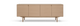 Lyst egetræ sideboard med fire glatte låger og slanke ben, frilagt på hvid baggrund.