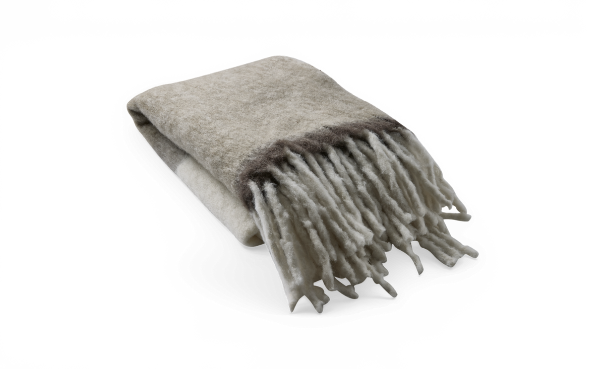 Sammenfoldet uldplaid med frynser i beige og grå nuancer, frilagt på hvid baggrund.