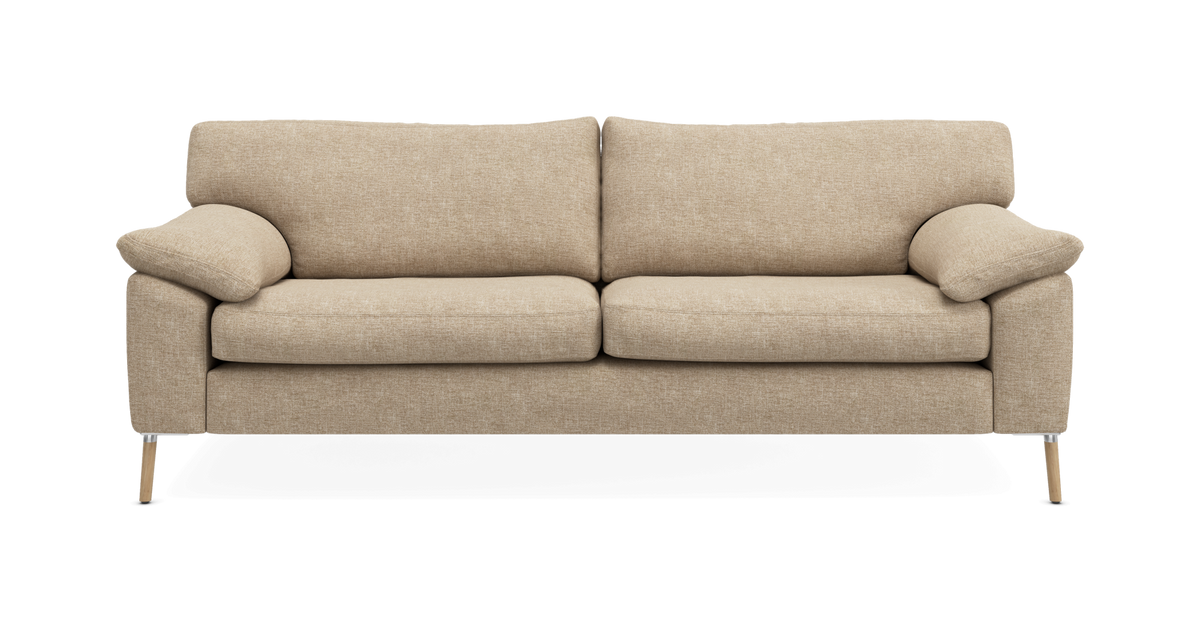 Beige 3-personers stofsofa med bløde puder og træben, fotograferet lige forfra på hvid baggrund.