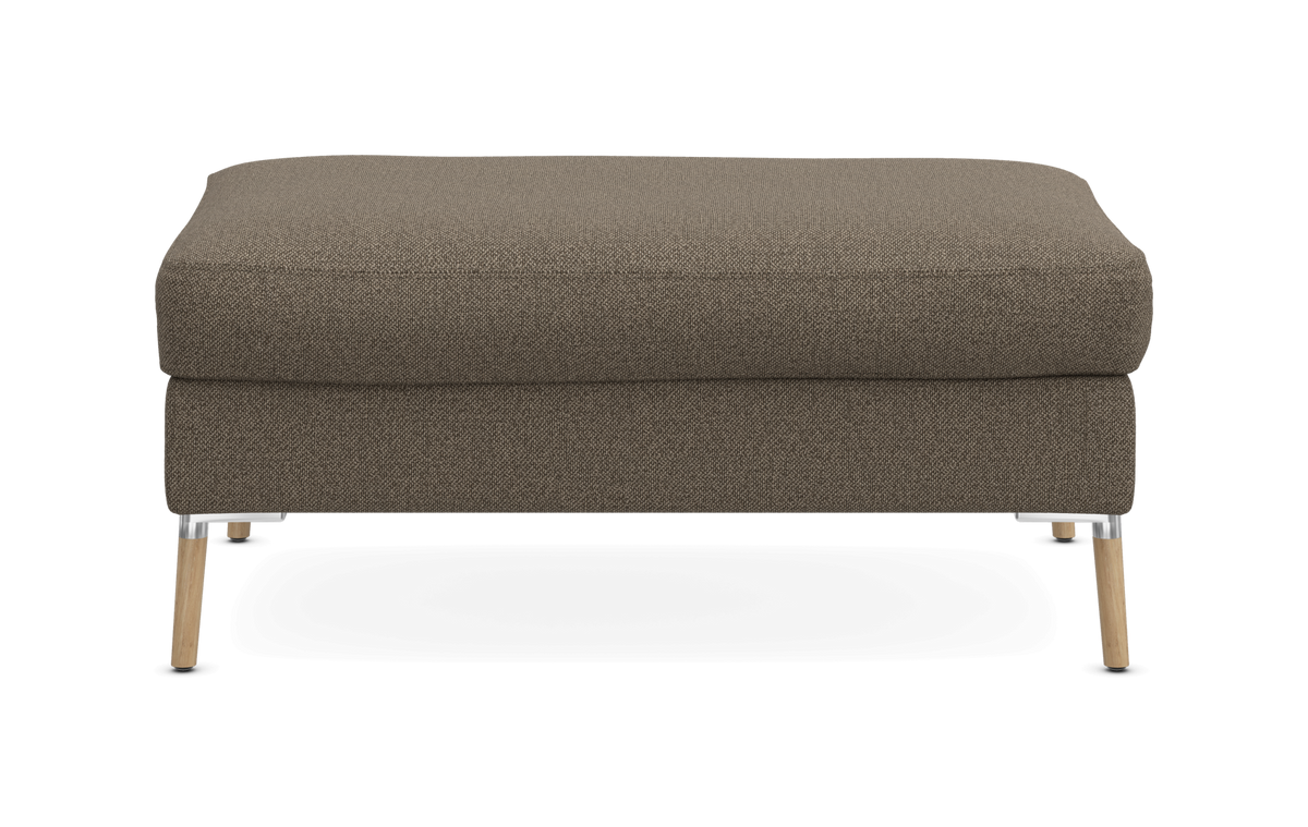 Brun polstret ottoman/skammel med træben og metaldetaljer, set forfra på neutral baggrund.