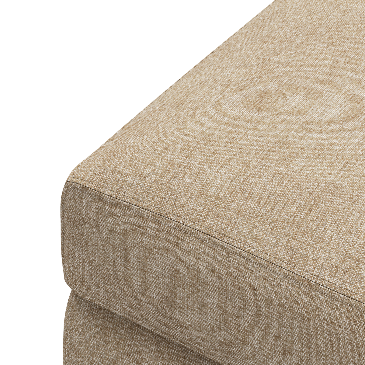 Nærbillede af beige stofbetrukket sofa- eller pufmodul set fra hjørnet.